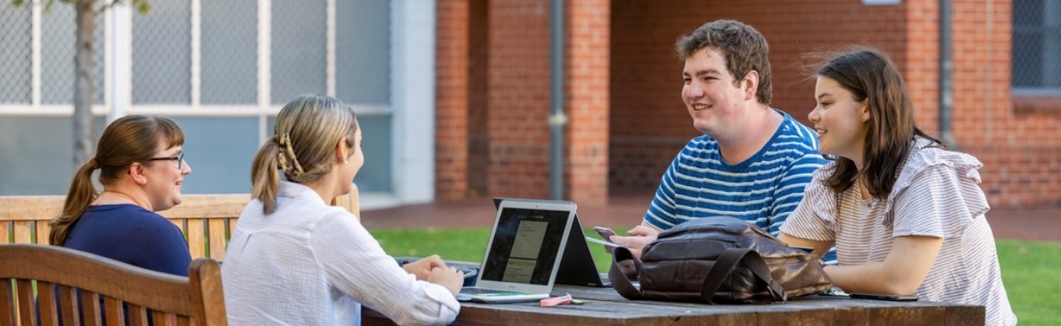 College students studying and talking outside.